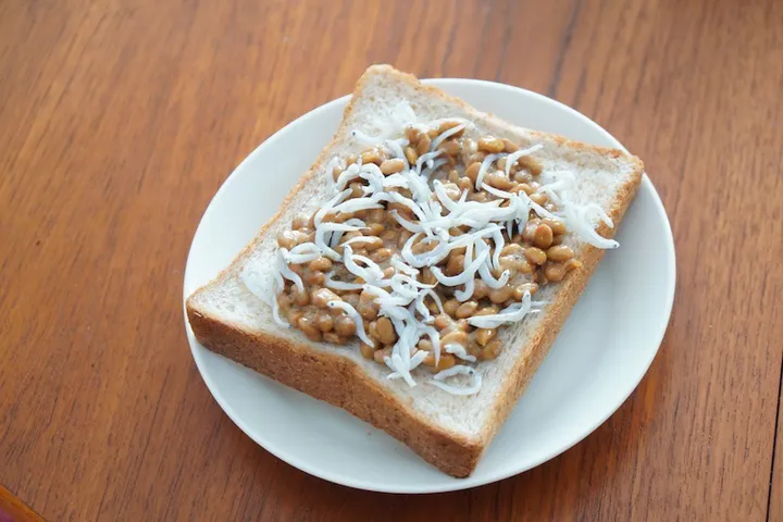 まずはタレをかけて混ぜた納豆、しらすを食パンにのせる。これにチーズをのせて焼いたら完成だ