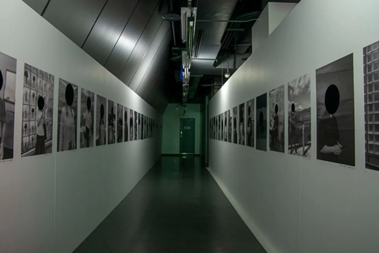 顔を黒丸で隠された人たちの写真が並んだ「恐怖心展」会場